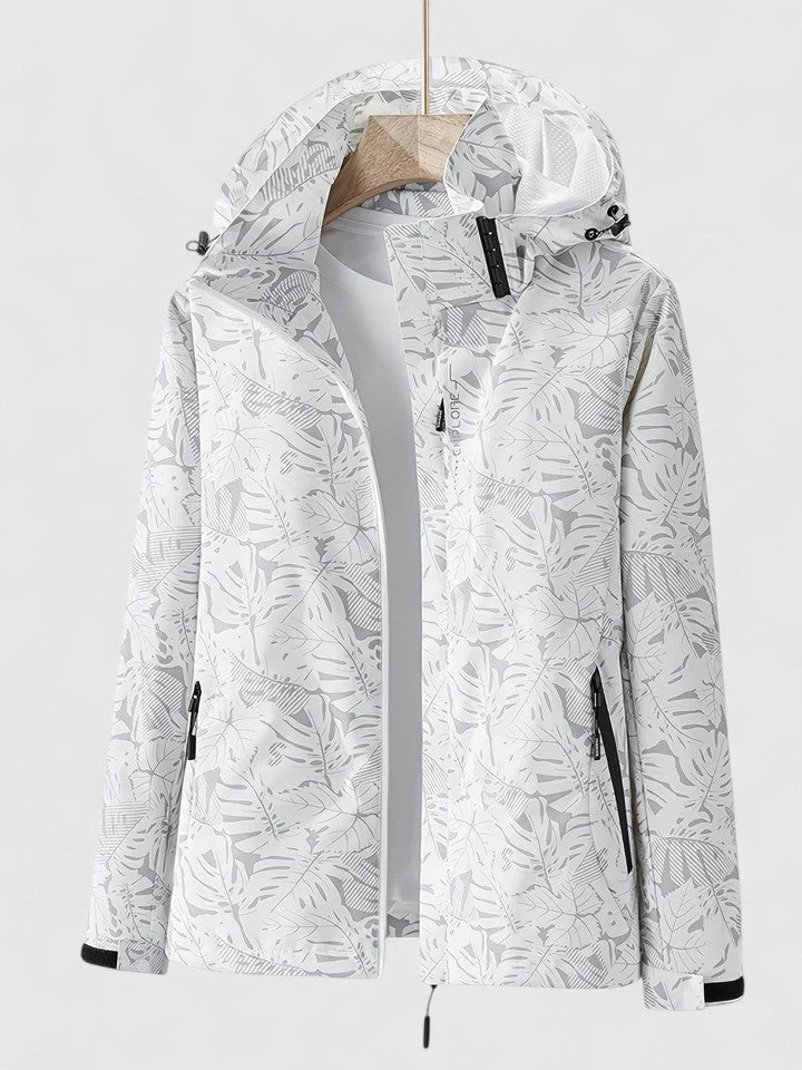 A woman wearing a botanical leaf-print jacket with a hood outdoors