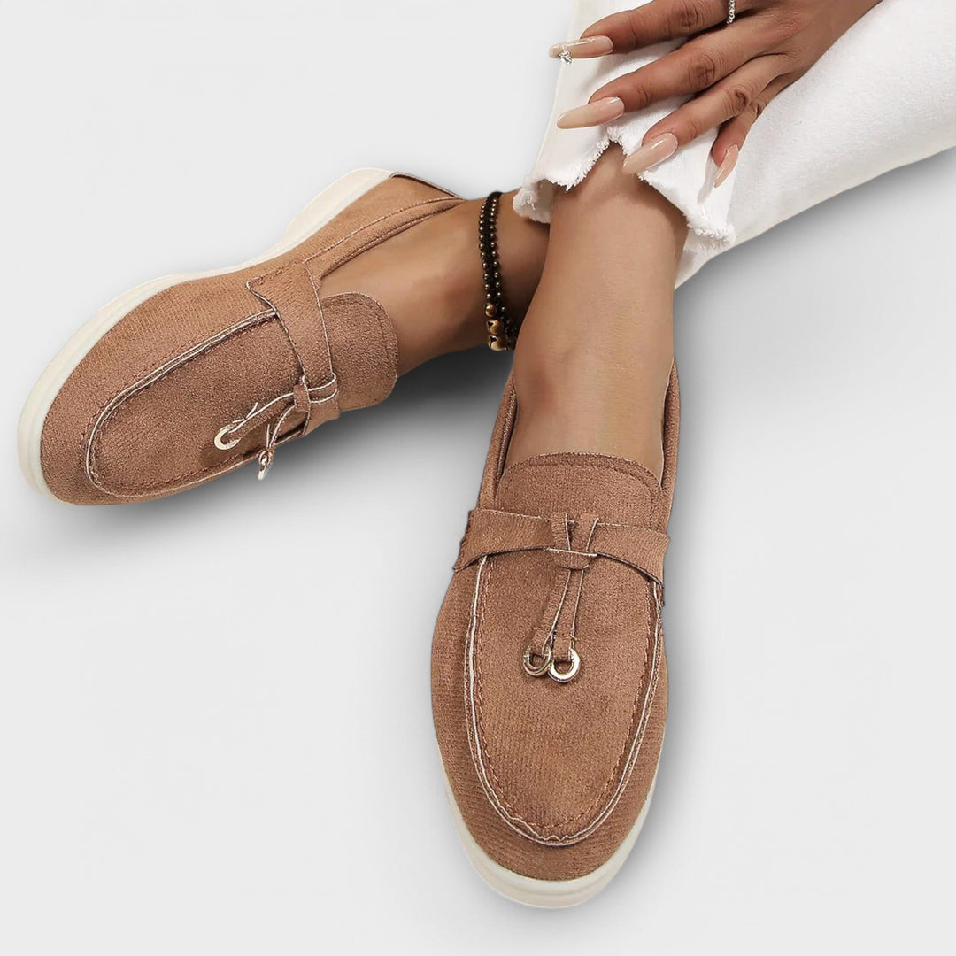 A woman wearing elegant loafers on a polished day out in the city.