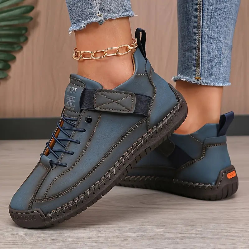 A woman wearing white lace-up orthopaedic sneakers with an adjustable strap.