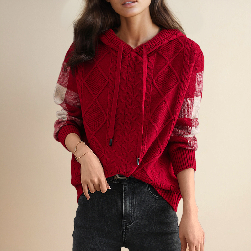 A woman wearing a soft cable-textured hooded sweater, cosy and warm with the hood down.