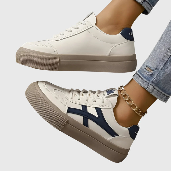 A woman standing comfortably in blue orthopaedic support sneakers with wide stabilising heels.