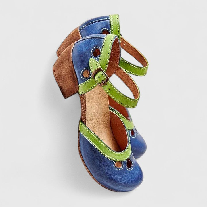 A woman in blue and green retro block heel shoes at a summer garden party.