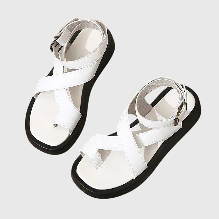 A woman in black chunky platform sandals with an ankle strap, standing confidently, feet cushioned and supported.