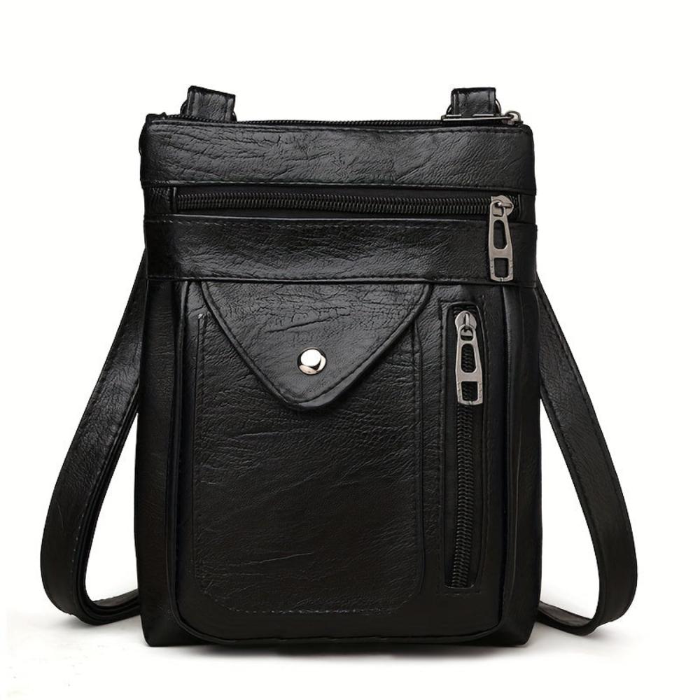 A woman wearing a compact vintage crossbody bag across her body while walking through town.