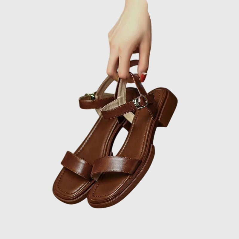 A woman in white square-toe ankle-strap sandals dressed for a summer brunch.