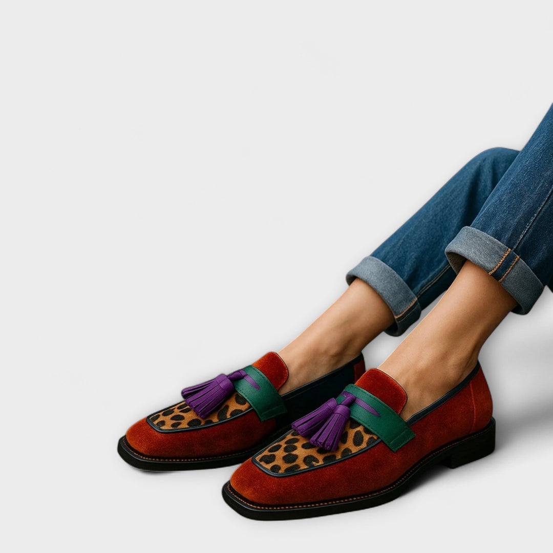 A woman wearing colourful multicolour loafers on a bright day in town.