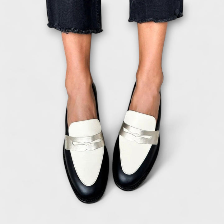 A woman wearing black metallic-shimmer loafers on an elegant evening out.