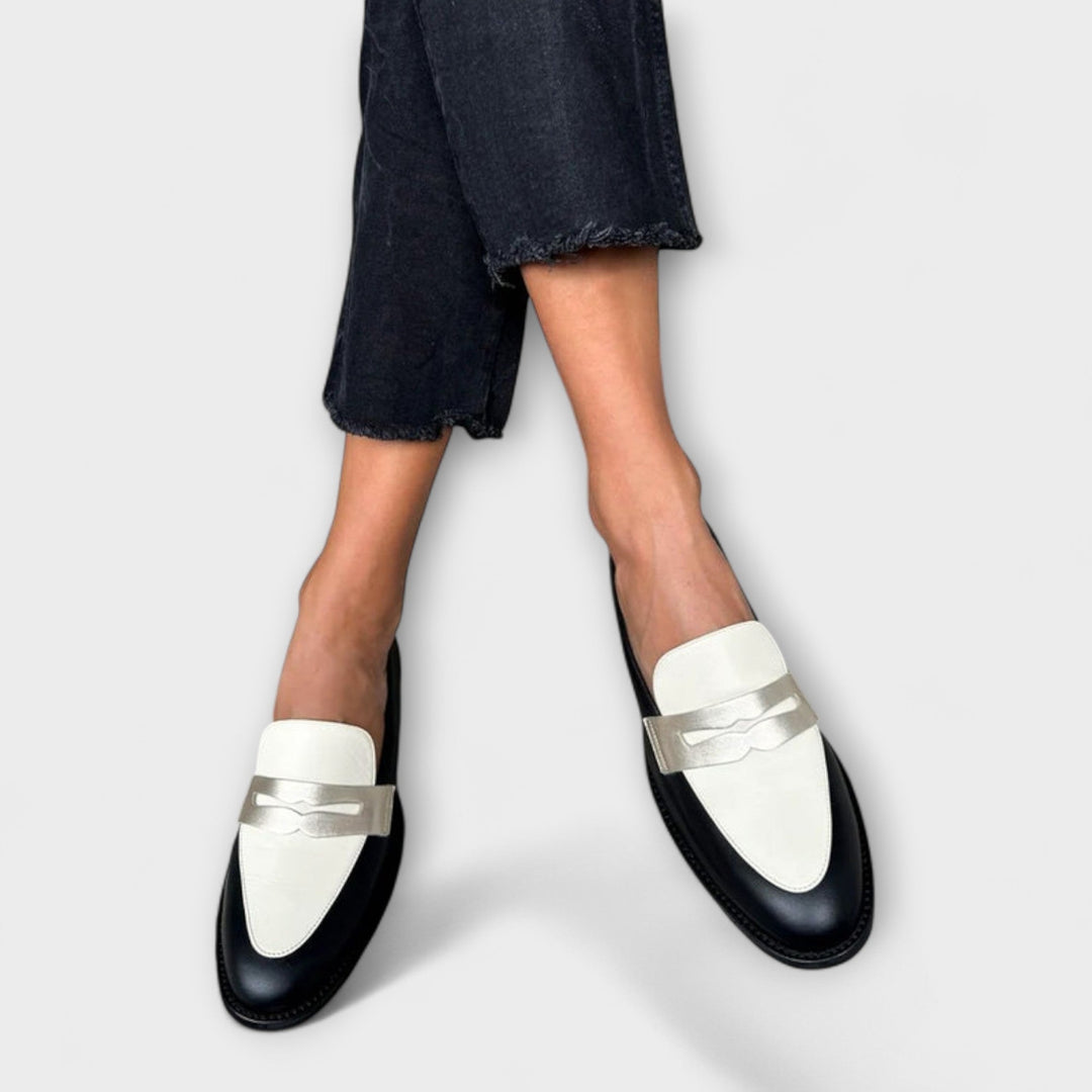 A woman wearing black metallic-shimmer loafers on an elegant evening out.