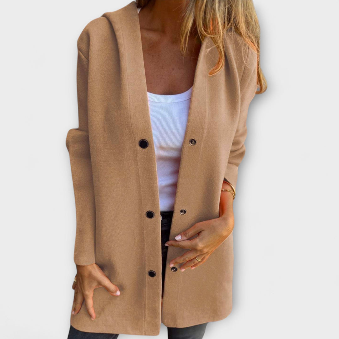 A woman wearing a relaxed longline hooded jacket with a button-through front over jeans.