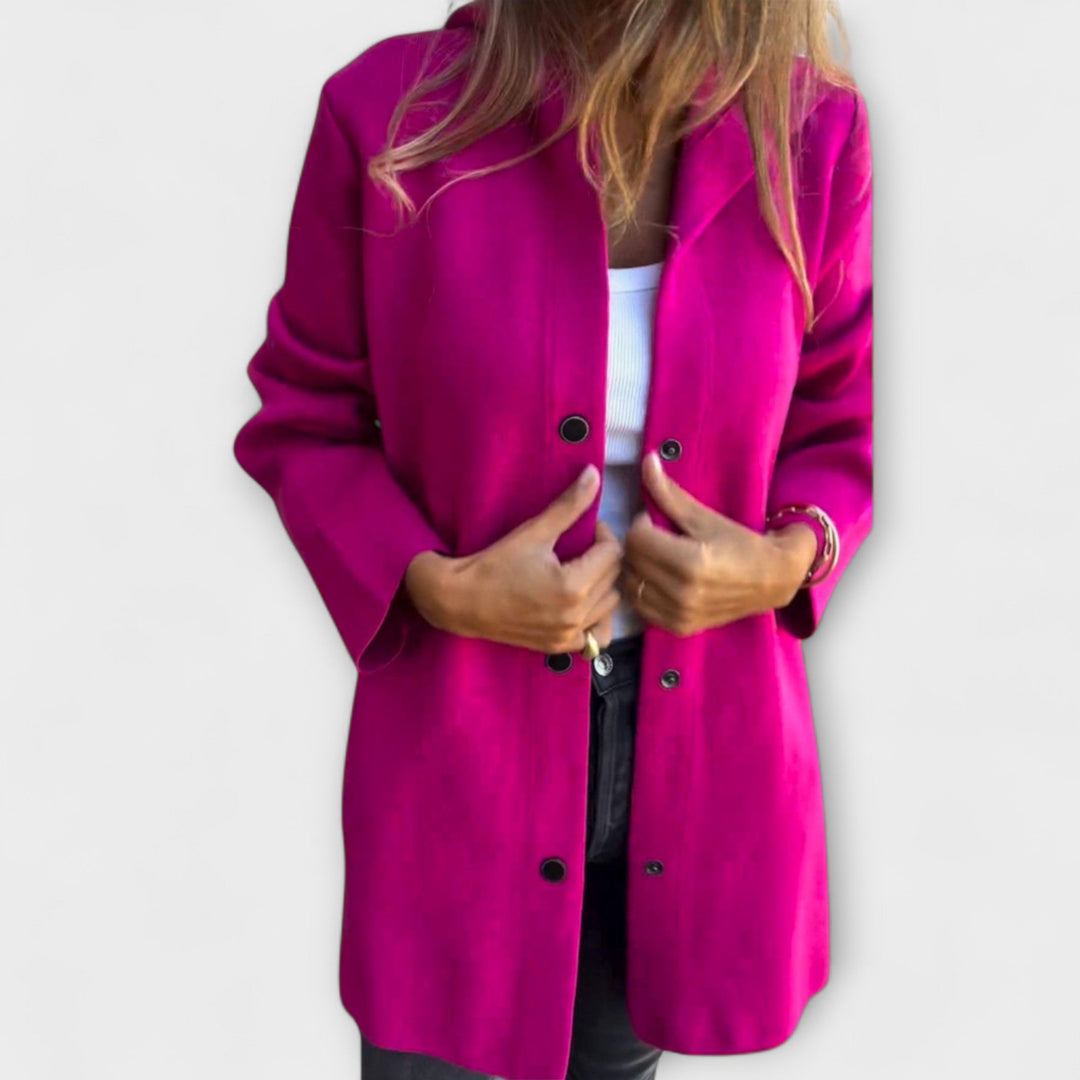 A woman wearing a relaxed longline hooded jacket with a button-through front over jeans.