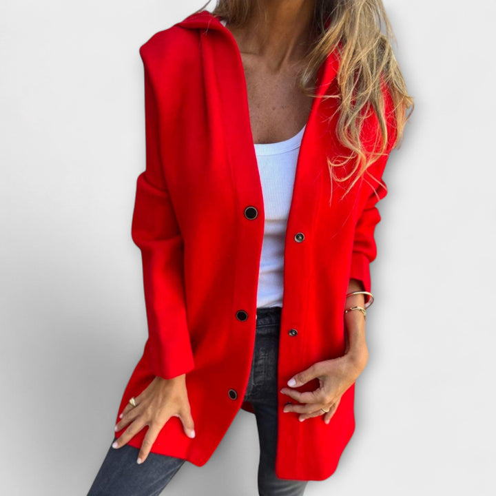 A woman wearing a relaxed longline hooded jacket with a button-through front over jeans.