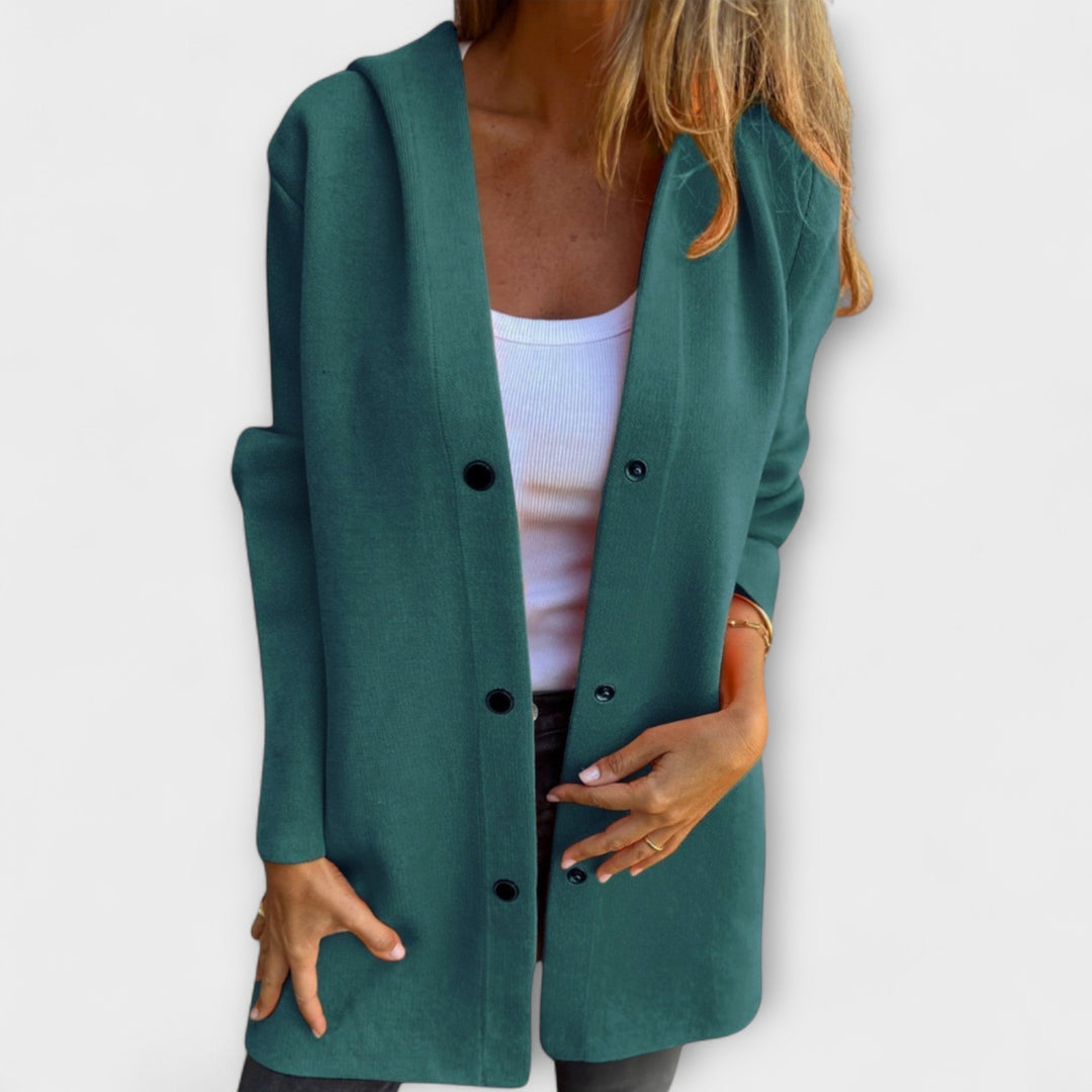A woman wearing a relaxed longline hooded jacket with a button-through front over jeans.