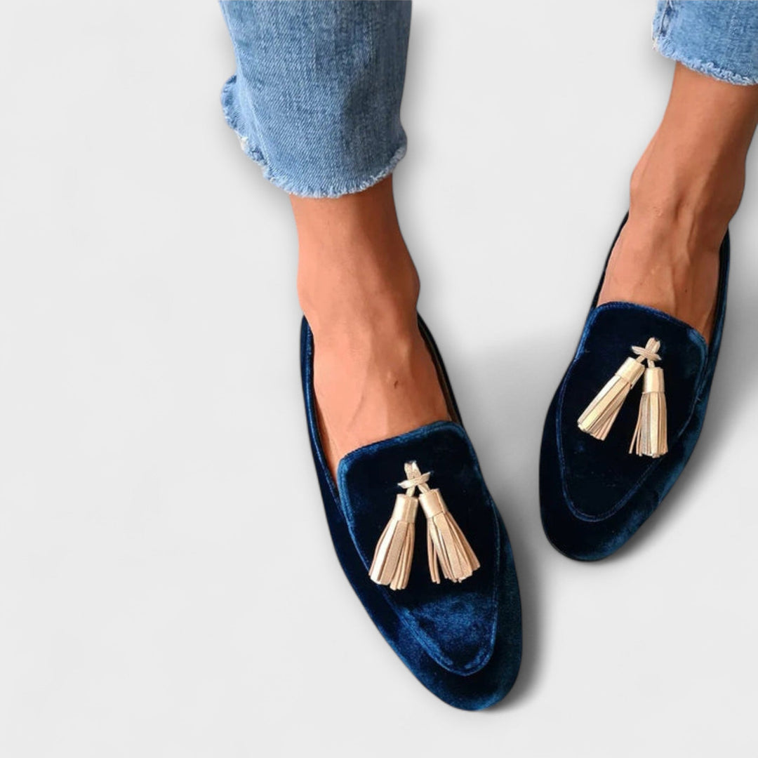 A woman wearing vintage-style loafers with decorative tassels and a relaxed outfit