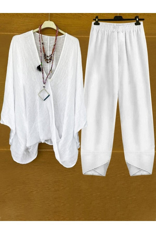 A woman wearing a flowing V-neck knot-detail top with matching flared pants.