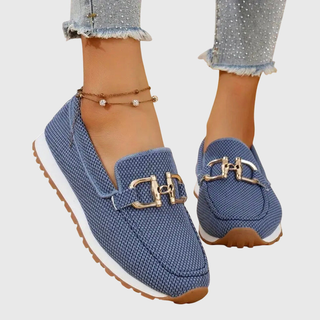 A woman in smart-casual orthopaedic loafer sneakers with a subtle golden detail.