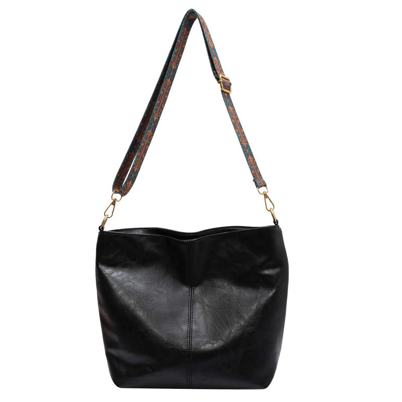 A woman carrying a vintage-style bag with a shoulder strap on a day out