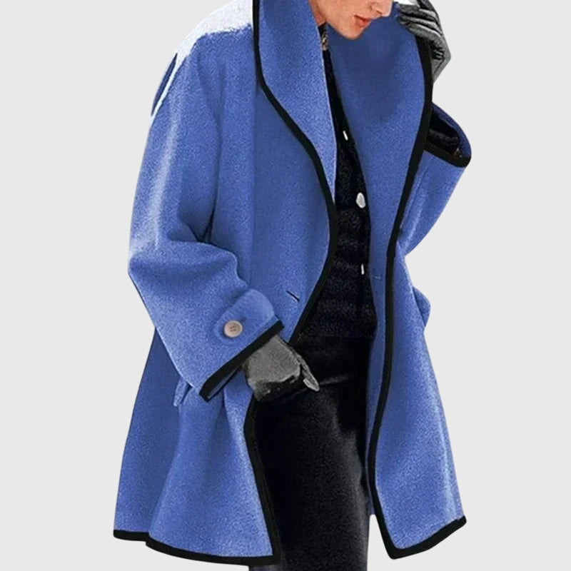 A woman wearing a blue swing-cut jacket with a black contrast trim