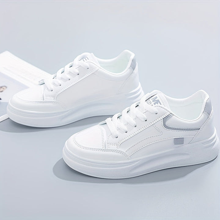 A woman in crisp white light comfort sneakers paired with jeans.