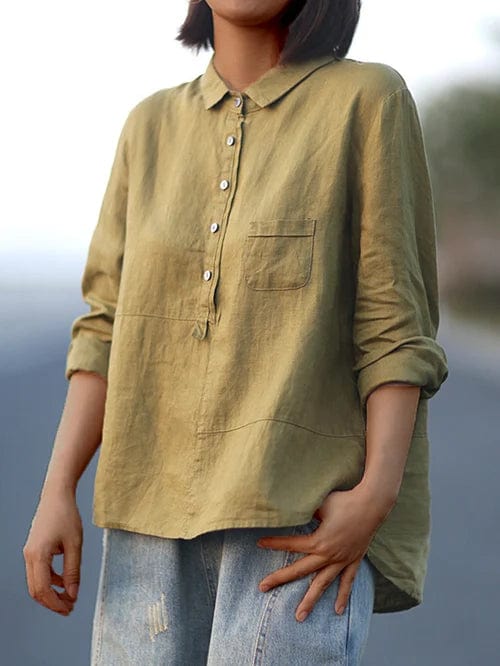 Woman wearing a plain flowing summer blouse in a warm solid colour, falling softly around her figure.