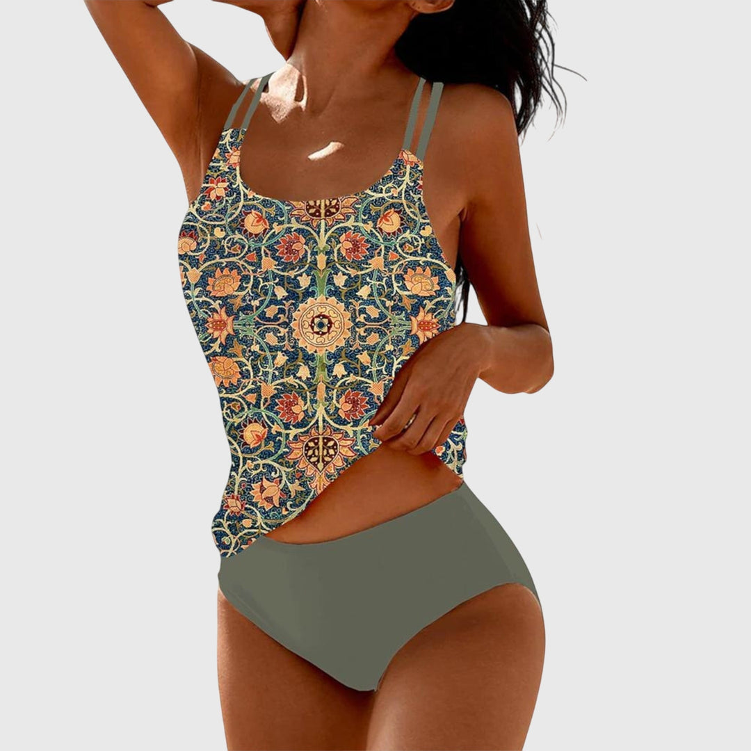 A woman by the sea in a coordinated printed two-piece swimsuit set, relaxed in the summer sun.