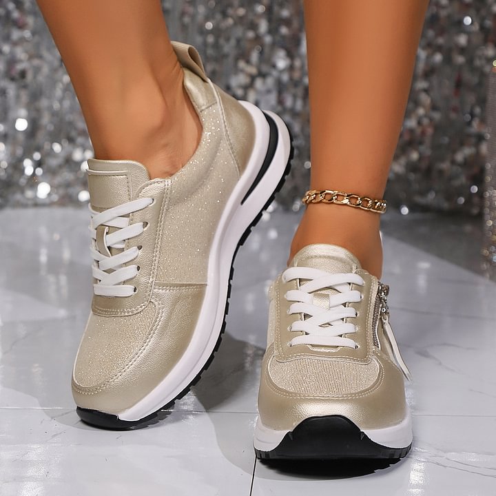 A woman in silver orthopaedic sneakers with a handy side zip.