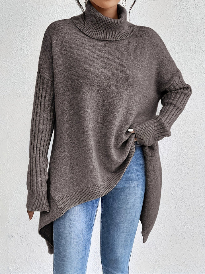 A woman wearing a stand-collar sweater with a chic asymmetric drape, warm and polished.