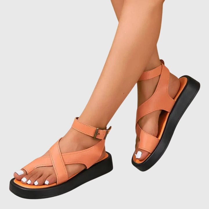 A woman in black chunky platform sandals with an ankle strap, standing confidently, feet cushioned and supported.