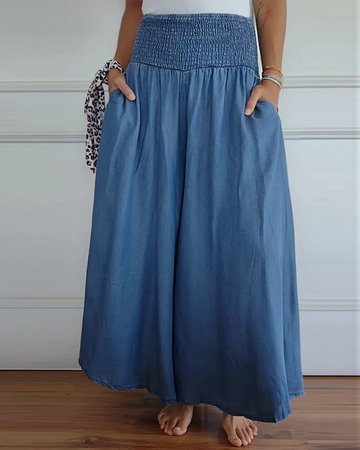 Woman wearing high-waist wide-leg pants with a tucked-in blouse, mid-stride.