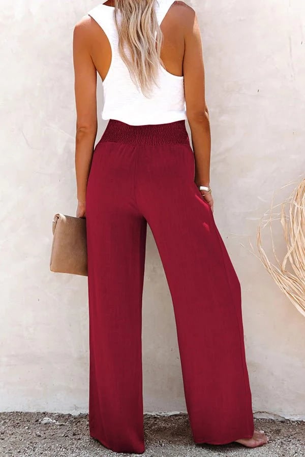 A woman in high-waisted loose wide-leg pants with subtle button detailing, styled for an elegant everyday look.