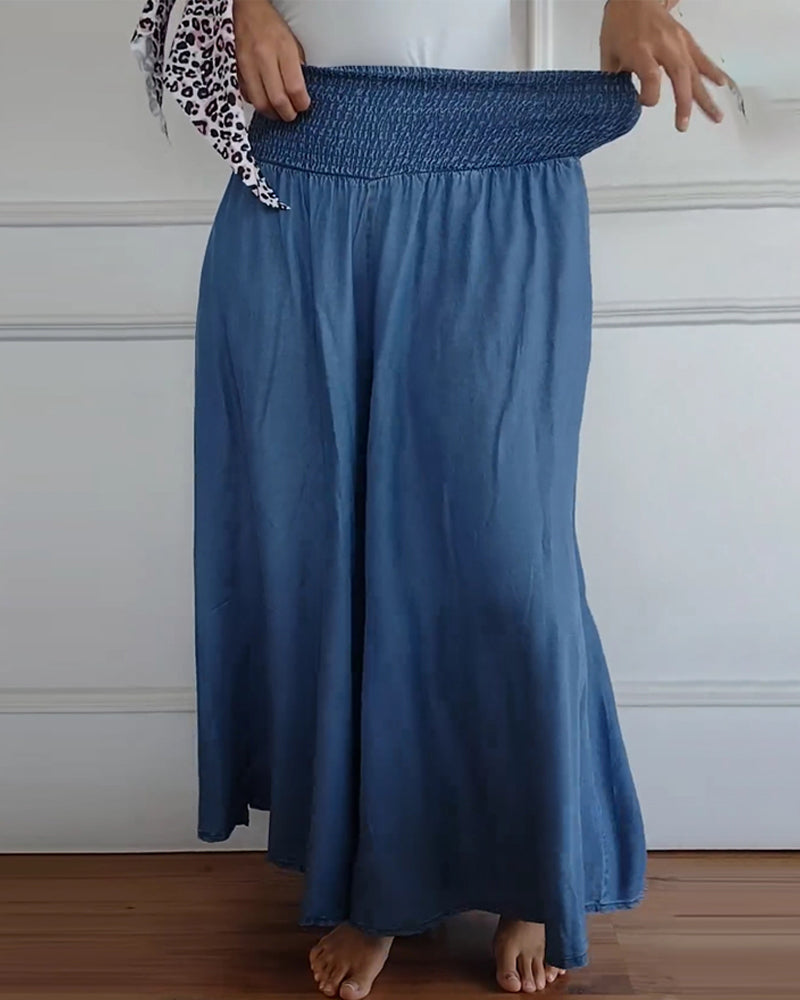 Woman wearing high-waist wide-leg pants with a tucked-in blouse, mid-stride.
