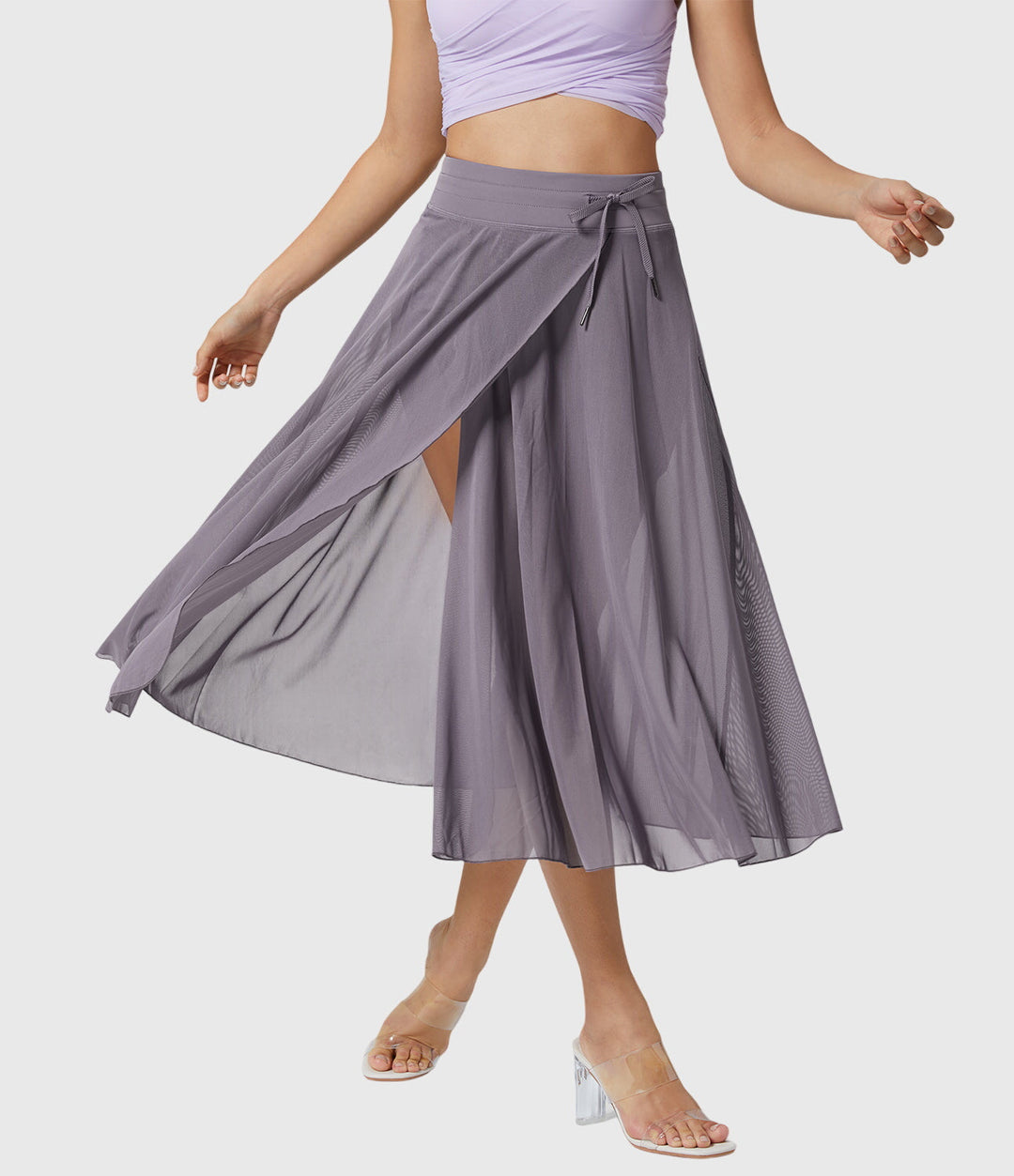 A woman in an elegant high-waisted flowing skirt, styled for a versatile day-to-evening look.