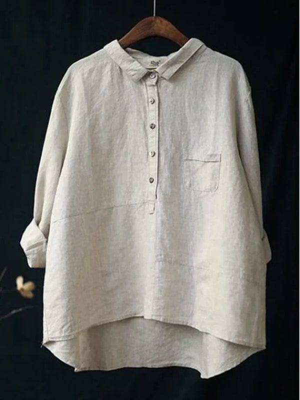 Woman wearing a plain flowing summer blouse in a warm solid colour, falling softly around her figure.