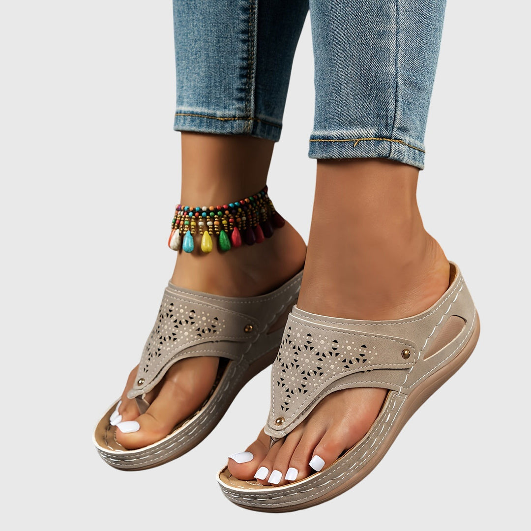 A woman in grey comfort flip-flops relaxing outdoors, feet cushioned and supported.