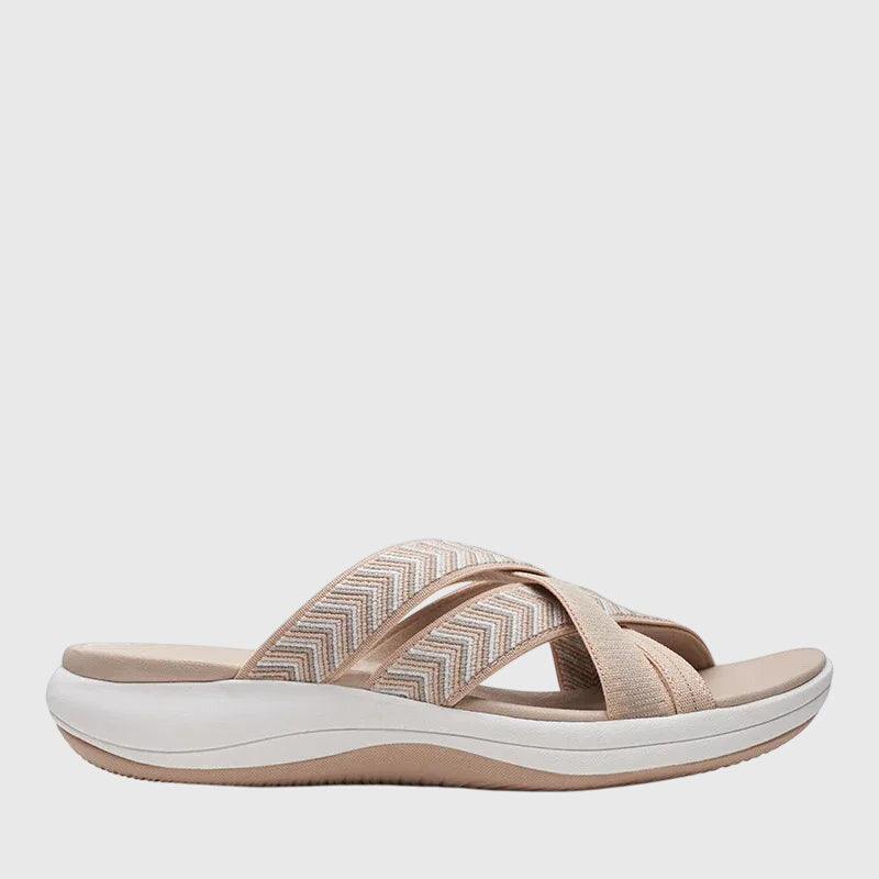 A woman in beige lightweight soft sandals walking easily on a sunny path, feet cushioned and supported.