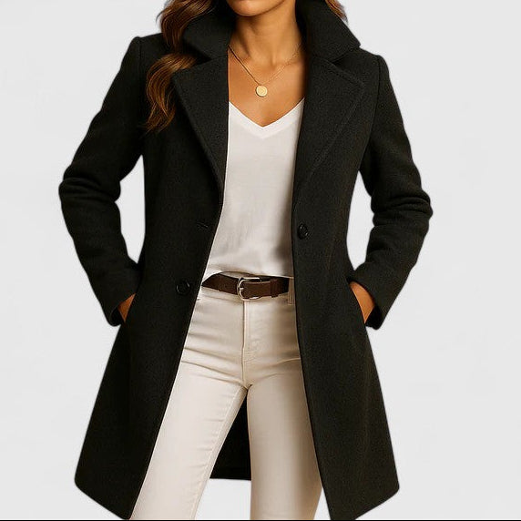 A woman wearing an elegant camel long coat with buttons, styled over jeans and boots in the city.