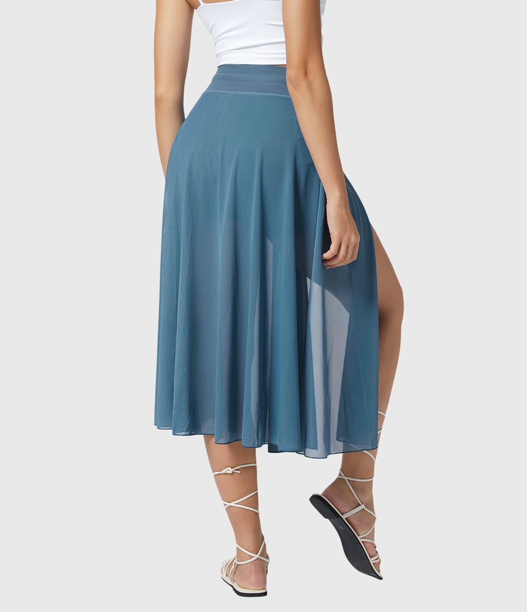 A woman in an elegant high-waisted flowing skirt, styled for a versatile day-to-evening look.