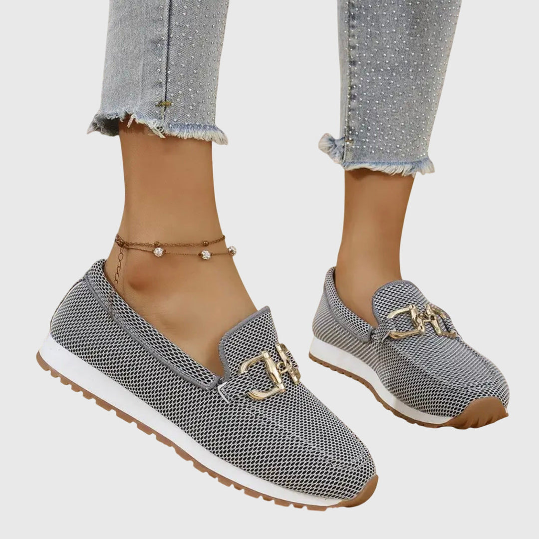 A woman in smart-casual orthopaedic loafer sneakers with a subtle golden detail.