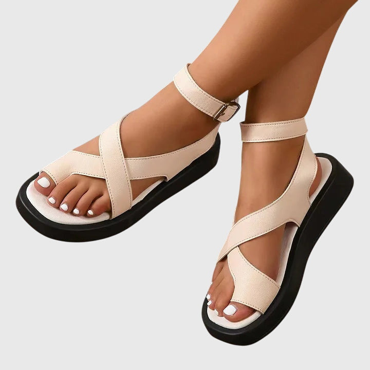 A woman in black chunky platform sandals with an ankle strap, standing confidently, feet cushioned and supported.