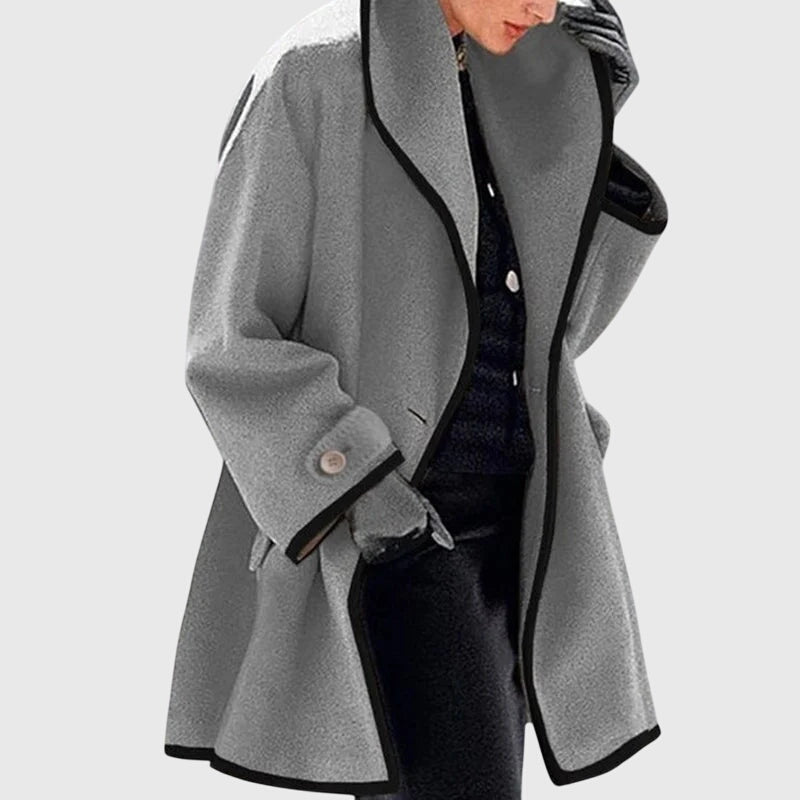 A woman wearing a blue swing-cut jacket with a black contrast trim