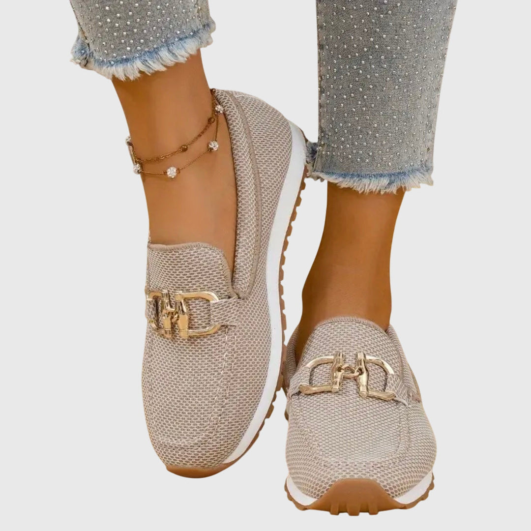 A woman in smart-casual orthopaedic loafer sneakers with a subtle golden detail.