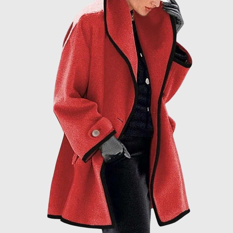 A woman wearing a blue swing-cut jacket with a black contrast trim