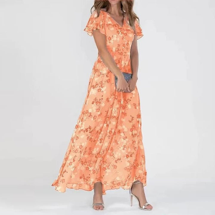 Woman wearing a long flowing wrap-effect maxi dress with a subtle floral print and floaty sleeves.