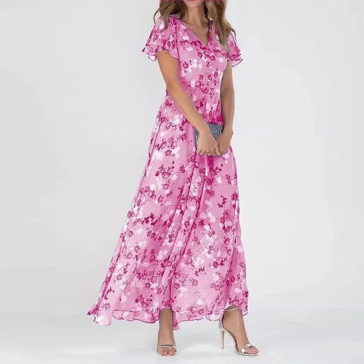 Woman wearing a long flowing wrap-effect maxi dress with a subtle floral print and floaty sleeves.