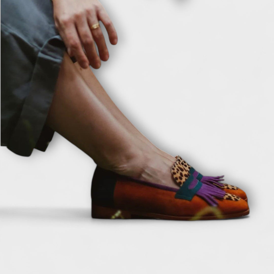A woman's colourful fringed loafers in rust, teal and purple with leopard-spot panels and a purple kiltie fringe.