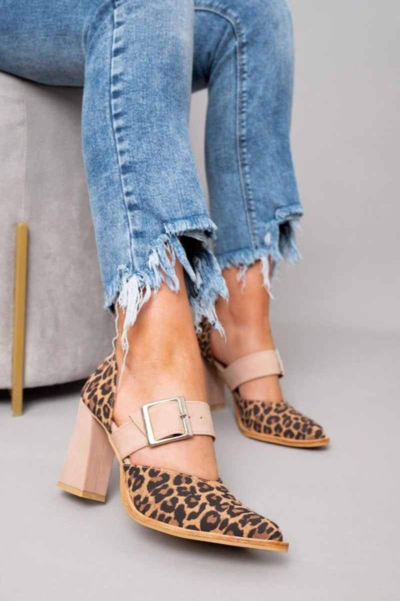 A woman wearing leopard-print pointed heels with a neutral buckled strap and block heel, stepping out in a polished outfit.
