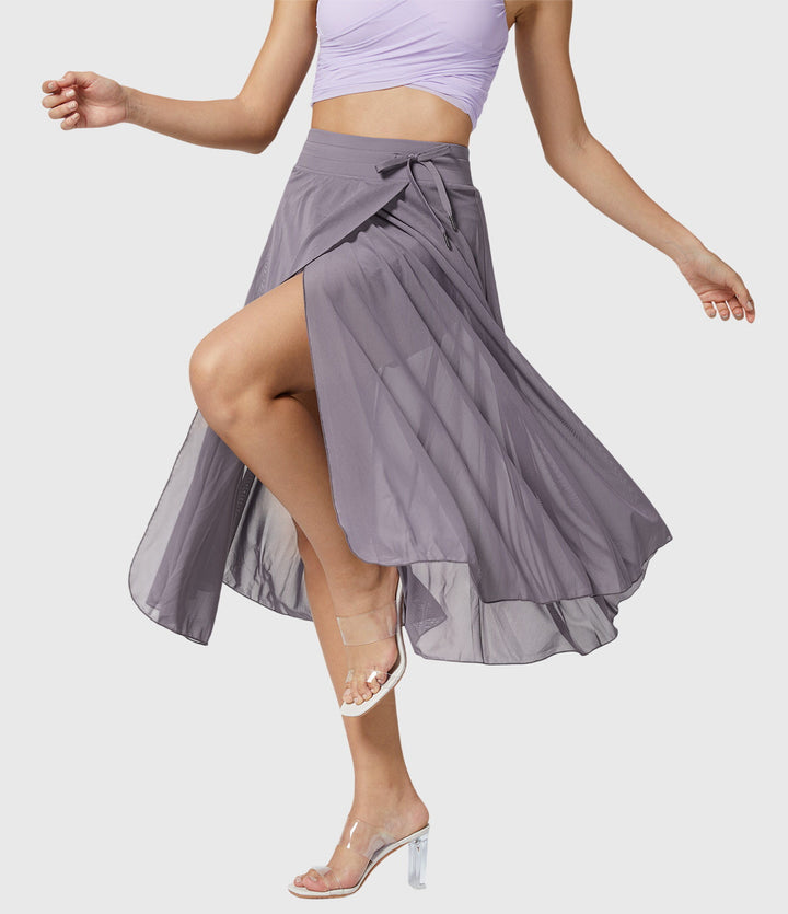 A woman in an elegant high-waisted flowing skirt, styled for a versatile day-to-evening look.