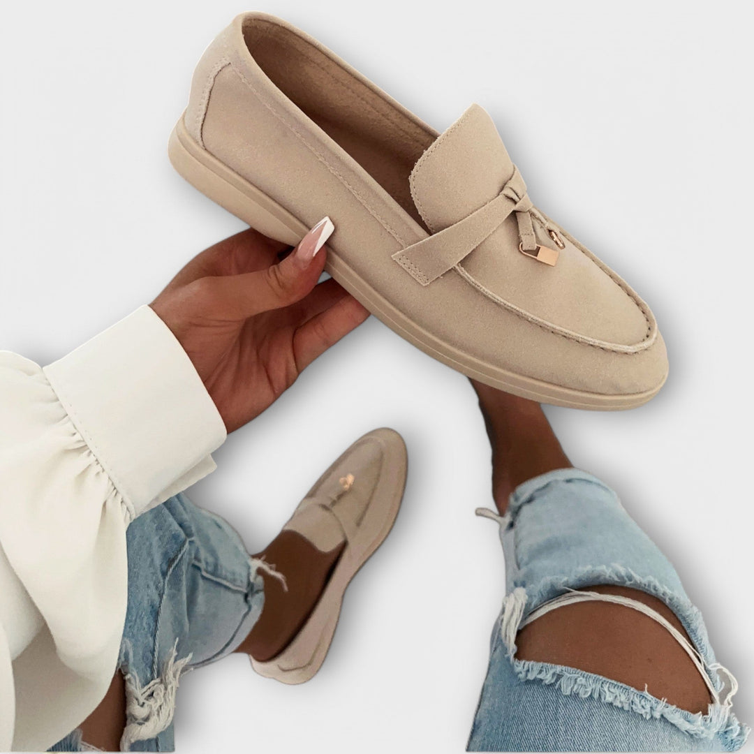 A woman wearing minimal slip-on loafers, styled for an easy everyday look.