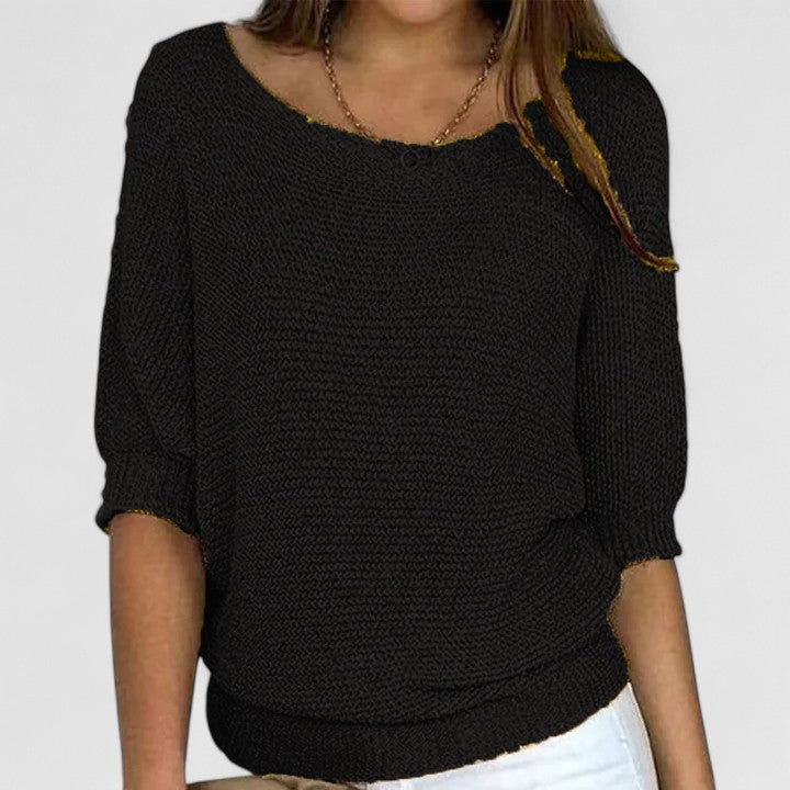 A woman wearing a soft purple sweater with a wide neckline and gently shaped fit.