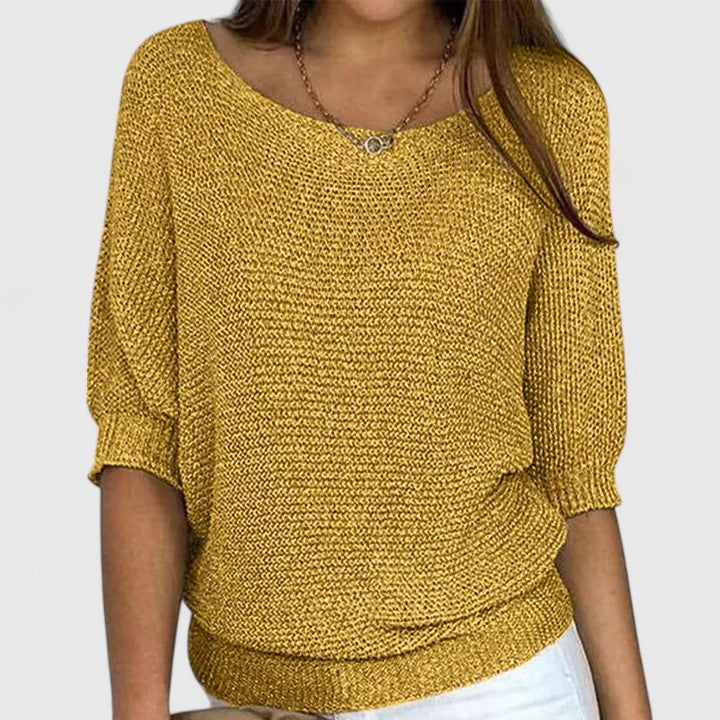A woman wearing a soft purple sweater with a wide neckline and gently shaped fit.
