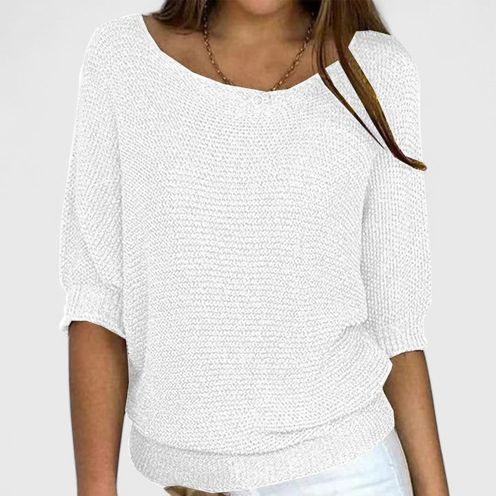 A woman wearing a soft purple sweater with a wide neckline and gently shaped fit.